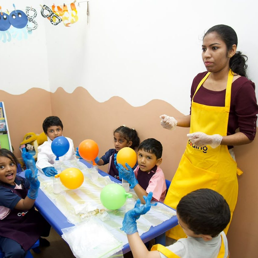 A nursery table set up with balloons and experiment materials during the fair.