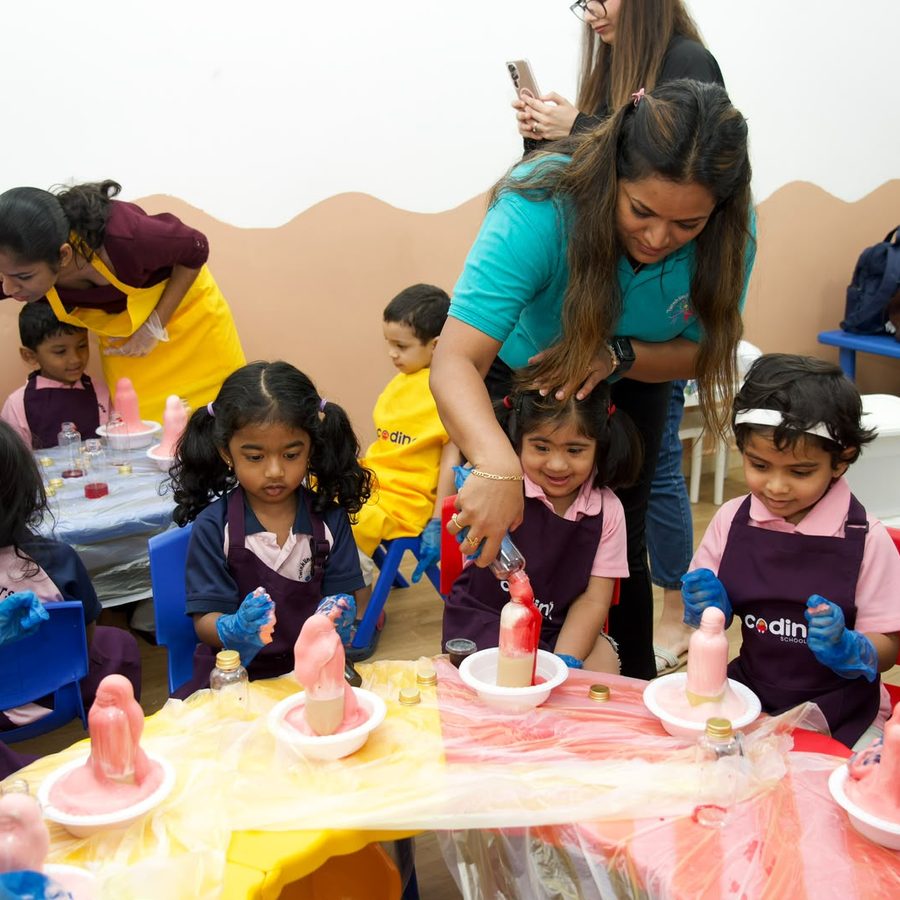 A busy experiment station with children and facilitators working together.